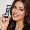 A woman holding a tube of RefectoCil No. 2 Blue Black professional brow tint shade with model result cream eye shadow against a light gray background.